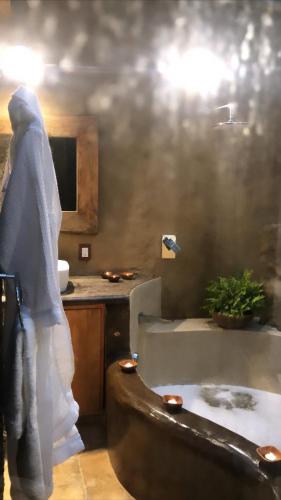 a person standing in a bathroom with a bath tub at Hotel Valle Místico in Tepoztlán
