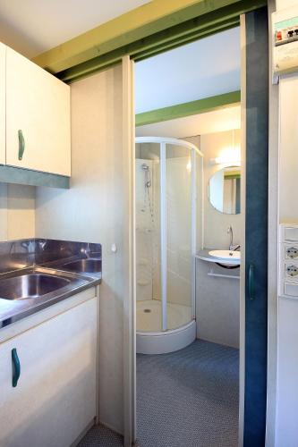 a small bathroom with a shower and a sink at Camping La Rueda in Cubelles