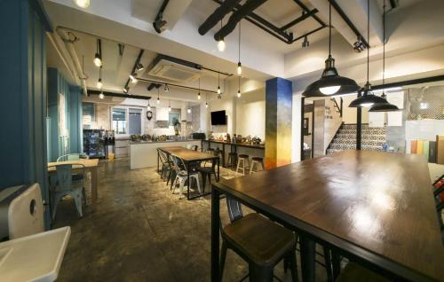 un restaurante con mesas y sillas en una habitación en Backpackers In Yeosu, en Yeosu