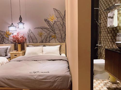 カントーにある09 Homestayのベッドルーム1室(壁に植物が飾られたベッド1台付)
