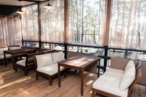 a restaurant with tables and chairs and a large window at Dachi Holiday home in Volzhskiy