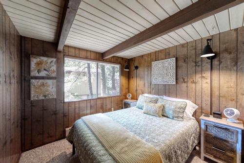 a bedroom with a bed in a room with wooden walls at Lakedale Lodge in Ronald