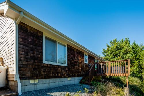 a brick house with a porch and a deck at Sunrise Serenity in Manzanita