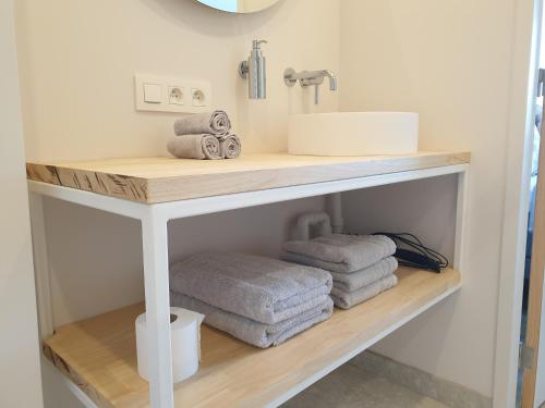 a bathroom with a sink and towels on a shelf at Snooze in Ostend