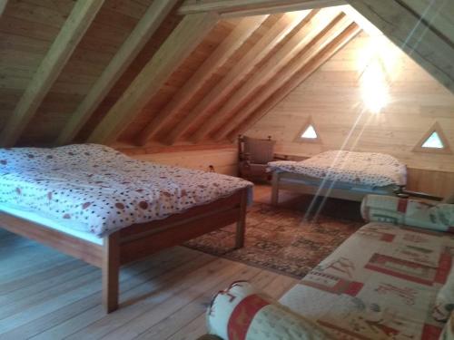 een zolderkamer met 2 bedden en een stoel bij Le Ptit Chalet in Valloire