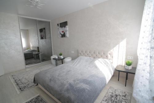 een slaapkamer met een groot bed en een spiegel bij Ніжність in Rivne