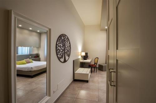 a bedroom with a bed and a desk and a mirror at B&B Palazzo Paciotti in Trani
