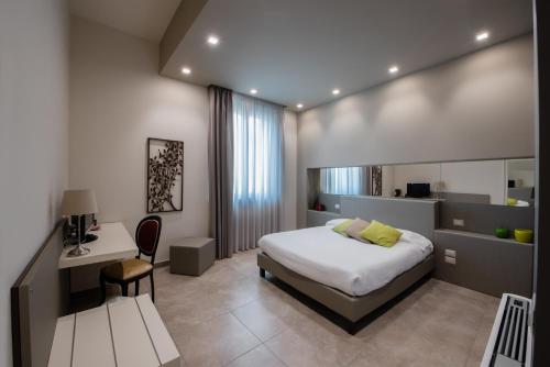 a bedroom with a bed and a desk and a chair at B&B Palazzo Paciotti in Trani