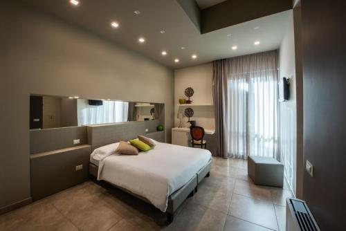 sypialnia z dużym łóżkiem i lustrem w obiekcie B&B Palazzo Paciotti w mieście Trani