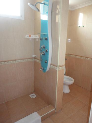 a bathroom with a shower with a toilet at Urban Rose Hotel & Apartments in Dar es Salaam