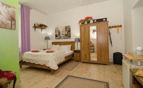 a bedroom with a bed and a cabinet with a mirror at Trubarjev Art Boutique hotel in Laško