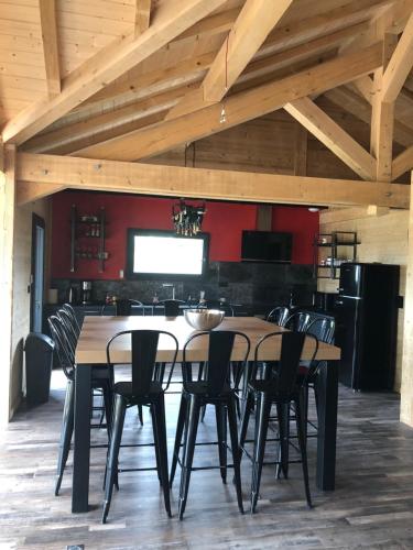 a dining room with a wooden table and chairs at L'ADRET DU TEMPS CHALET 10 PERSONNES 170m2 in Gérardmer