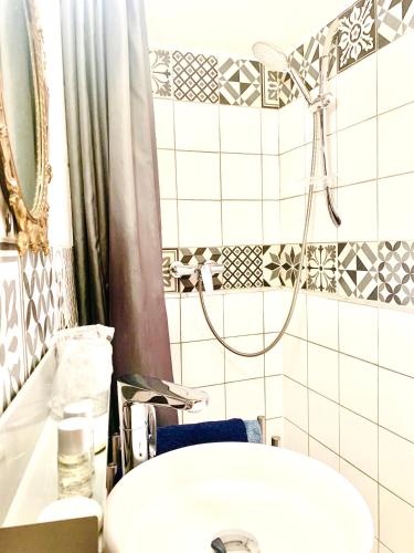 a bathroom with a sink and a shower at Hôtel Paul Riquet in Béziers