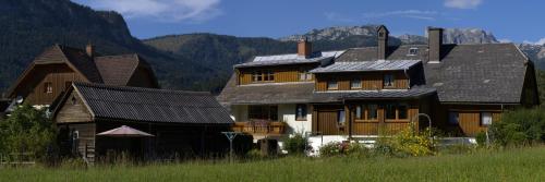 ein großes Holzhaus mit Bergen im Hintergrund in der Unterkunft Haus Hildegard in Tauplitz