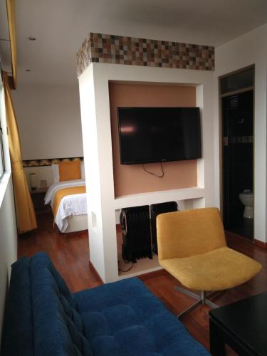 a living room with a couch and a tv on a wall at Hotel SJ in Mosquera