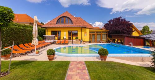 a house with a swimming pool in the yard at Hotel Mayer Alsóörs in Alsóörs