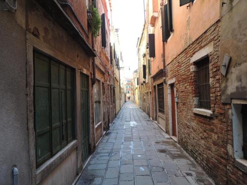 an empty alley way between two brick buildings at Biennale Appartamento grande in Venice