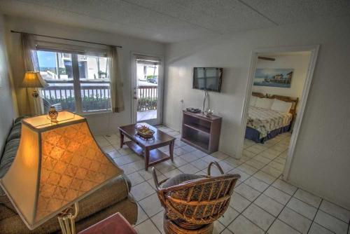 a living room with a bed and a television at SURFSIDE II 107 condo in South Padre Island