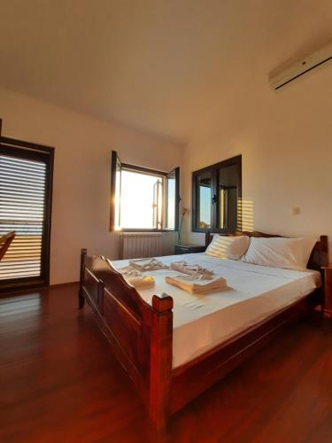 1 dormitorio con 1 cama grande con sábanas blancas en Villa Lipski en Sveti Stefan