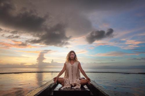 a woman sitting in a boat on the ocean at Hotel Villas Flamingos in Holbox Island