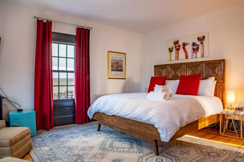 a bedroom with a large bed with red curtains at Addison Choate in Rockport