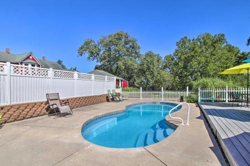 a swimming pool in a yard with a white fence at Cozy Ironton Cabin with Shared Pool and Private Patio! in Ironton