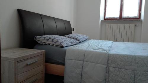 1 dormitorio con 1 cama grande y cabecero negro en Appartamento Le Cascate, en Cittiglio