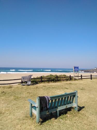 a blue bench sitting next to the beach at Sancta Maria 10 - Ultimate in luxury & majestic sea views includes private entertainment deck - Free wifi in Kingsburgh