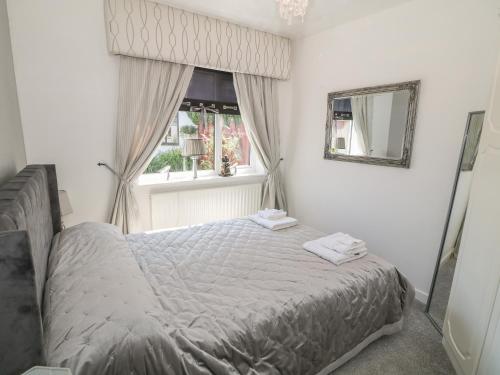 een slaapkamer met een bed en een raam bij Beachway in Holywell