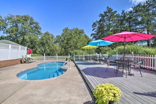 a patio with a table and umbrella and a pool at Turtle Rock - Ironton Cabin with Furnished Patio! in Ironton