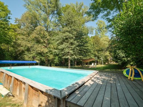 a swimming pool on a wooden deck next to a wooden deck at Sunny water mill with heated swimming pool in Brandonnet