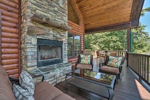 a living room with a fireplace on a deck at Hayesville Cabin with Game Room and Mtn Views! in Hayesville