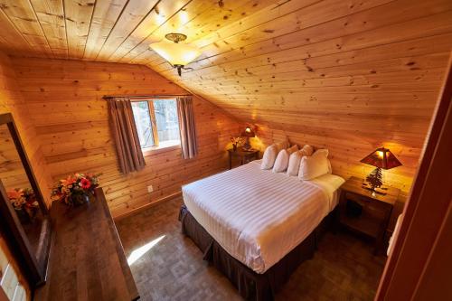 1 dormitorio con 1 cama en una cabaña de madera en Castle Mountain Chalets, en Castle Junction
