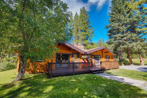 a log cabin with a balcony in a yard at Castle Mountain Chalets in Castle Junction