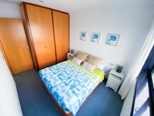 een kleine slaapkamer met een bed en een houten deur bij Ventana al roque apartamento con vistas al mar in Santa Cruz de Tenerife