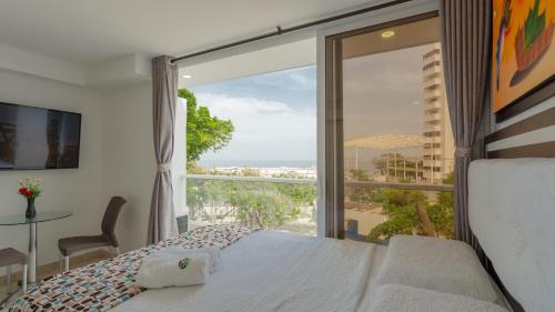 a bedroom with a bed and a view of the ocean at Hollywood Beach Suite in Cartagena de Indias