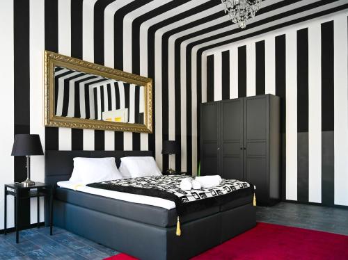 ein Schlafzimmer mit einem Bett mit einer schwarz-weißen gestreiften Wand in der Unterkunft Highlight Apartment St Charles Church in Wien