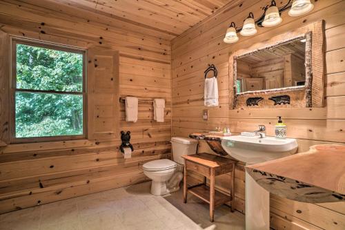 a log cabin bathroom with a sink and a toilet at Hayesville Cabin with Game Room and Mtn Views! in Hayesville