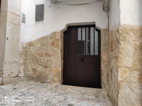 a black door in the side of a stone building at Il Tufo D'amare appartamento affitti brevi in Rutigliano