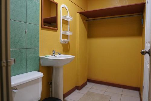 La salle de bains est pourvue d'un lavabo et de toilettes. dans l'établissement Hotel Heliconia Los Chiles, à Los Chiles