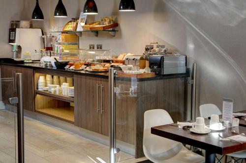 a kitchen with a counter with food on it at Best Western Plus Delmere Hotel in London