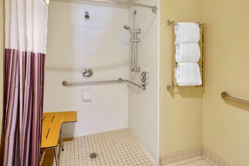 a bathroom with a shower and a toilet with towels at La Quinta by Wyndham Miami Cutler Bay in Cutler Ridge