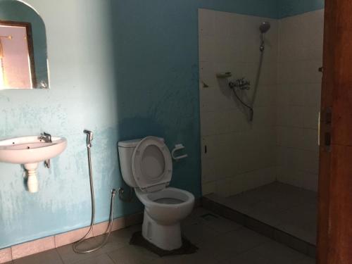 a bathroom with a toilet and a sink and a shower at Anak Rinjani Guest House in Senaru