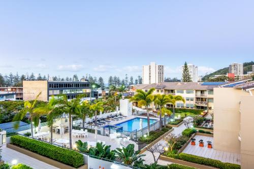 ゴールドコーストにあるThe Village Holiday Apartments at Burleigh Headsのヤシの木が植わるリゾートの空中ビュー