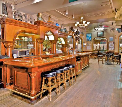 a bar in a restaurant with stools at a counter at Historic Anchorage Hotel in Anchorage