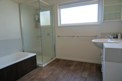a bathroom with a shower and a sink and a tub at Baillieu Breeze in Point Lonsdale