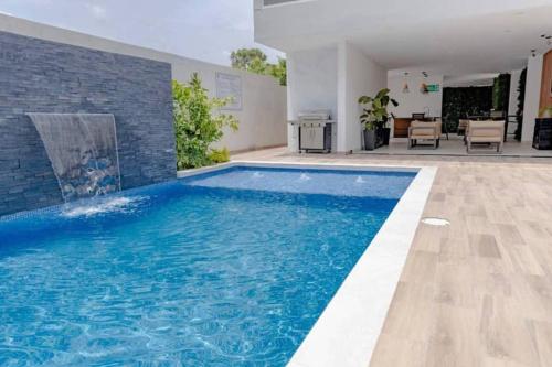 una piscina de agua azul en una casa en Moderno y acogedor condominio en zona exclusiva en San Pedro Sula