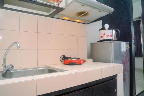une cuisine avec un évier et un réfrigérateur dans l'établissement Good Homey and Simply Studio Margonda Residence 3 Apartment By Travelio, à Kemirimuka Tiga