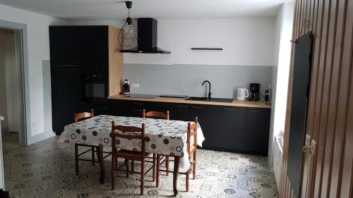 a kitchen with a table with chairs and a sink at A 2 pas du lac in Xonrupt-Longemer