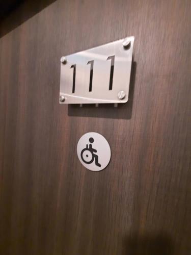 a sign on a restroom door with a sign for a handicapped at Hotin Inn in Kuching